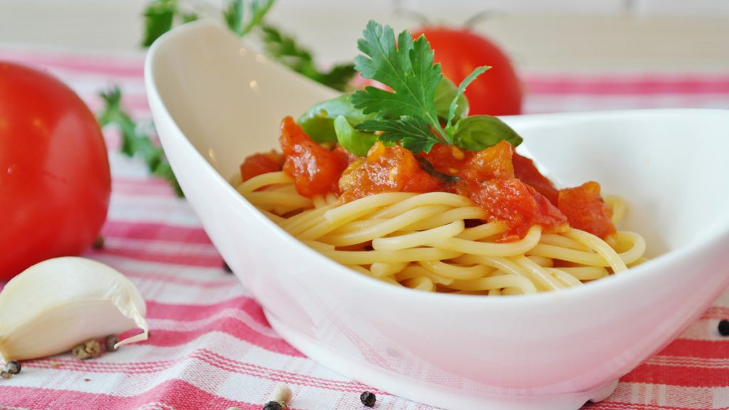 Bowl of delicious looking spaghetti with tomatoes and parsley