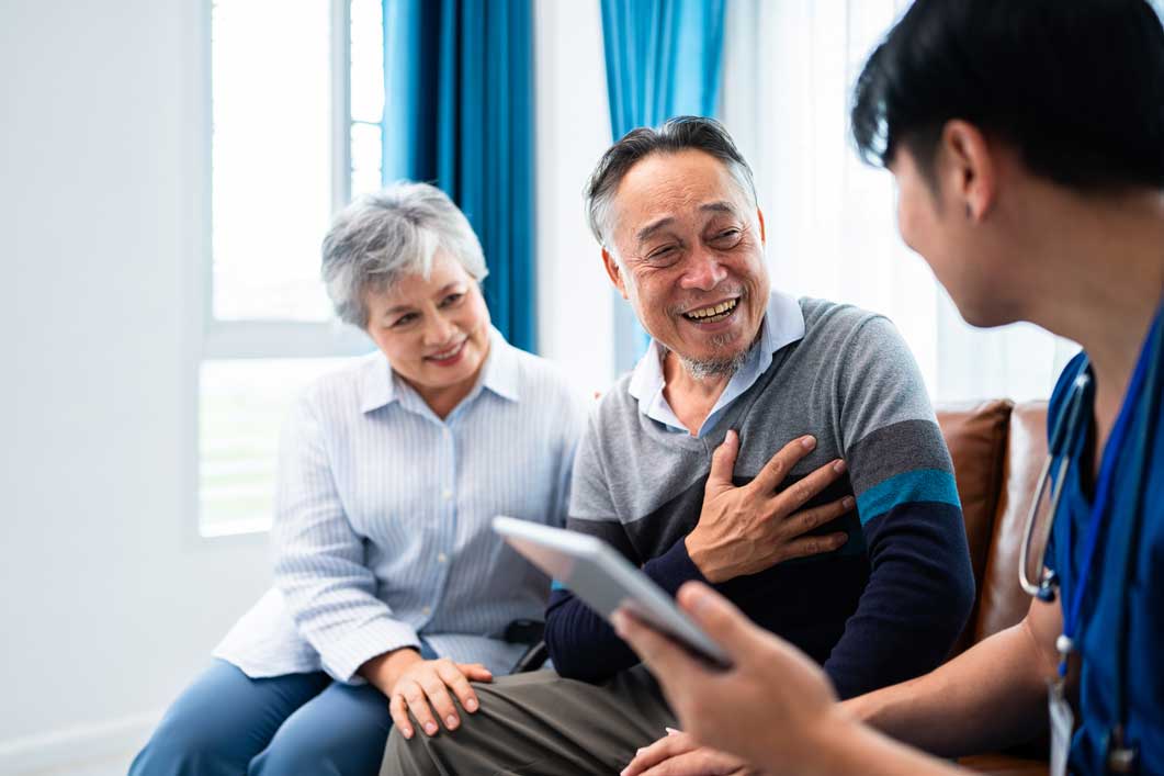 Happy couple - seated - smiling at healthcare provider